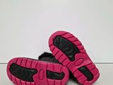 pink and black shoes on a white surface with a white background