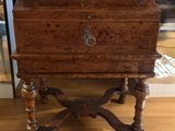 a small wooden box on a stand on a hard wood floor