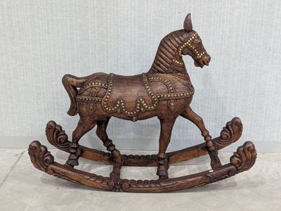 a wooden rocking horse that is sitting on the floor