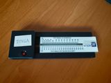 une calculatrice posée sur une table, sur laquelle est collé un autocollant