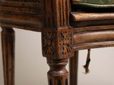 a close up of a chair with a green cushion on it