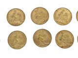 a close up of a bunch of gold coins on a white surface