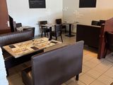 seating area in a restaurant with tables, chairs, and couches