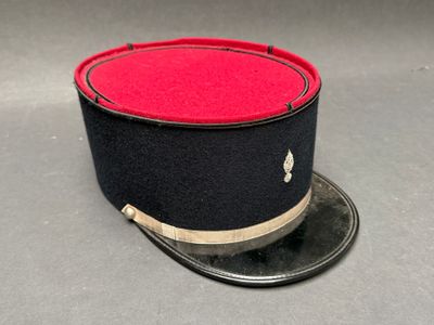 une image représentant un chapeau orné d'un ruban rouge et noir