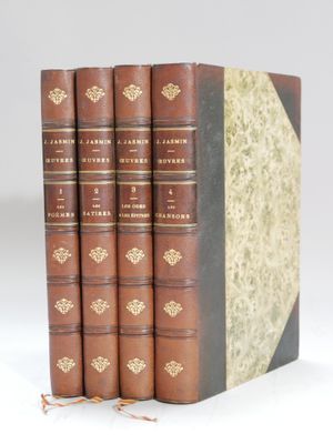 a set of four books sitting on top of each other on a white surface