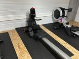une salle de sport équipée d'une rangée d'appareils de musculation fixes