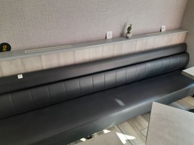 un banc en cuir noir dans un coin de la pièce
