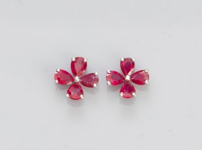 a pair of ruby colored earrings on a white surface