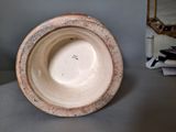 a small bowl sitting on a table with a mirror in the background