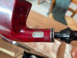 a red pipe sitting on top of a table next to a pair of scissors