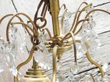 a gold chandelier with a glass ball hanging from it