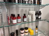 many different types of hair products displayed on a glass shelf