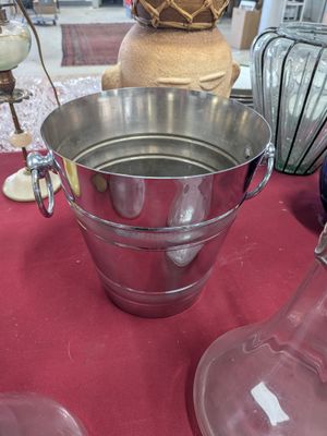 a large metal bucket with a handle on a table
