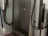 une grande porte en acier inoxydable dans une salle de bains équipée d'une douche