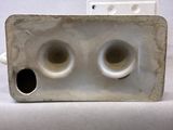 a white object with two holes in the middle of it