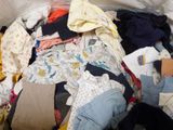 a pile of clothes that is sitting on a bed