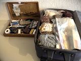 une valise posée sur une table à côté d'une boîte de laine