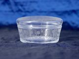 a clear glass container with a lid on a table