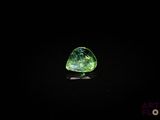 un gros plan d'un diamant vert et noir sur une surface noire