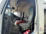 a white truck with its door open and a red canister in the back