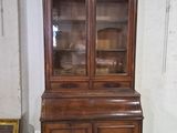 un meuble en bois avec une porte en verre dans une pièce