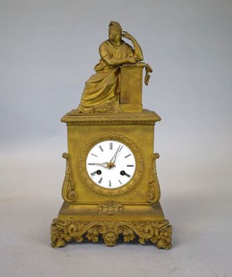 une horloge en or surmontée d'une statue