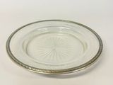 a glass plate with a silver rim on a white table