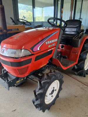 une photo d'un tracteur rouge garé dans un garage