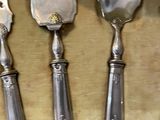 five spoons and two spoons sitting on a table