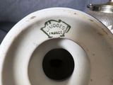 a white porcelain vase with a green label on it