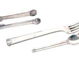 three spoons and a fork on a white surface