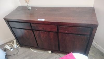 a wooden dresser with a glass vase on top of it