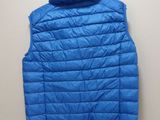 a blue vest hanging on a wall next to a white wall