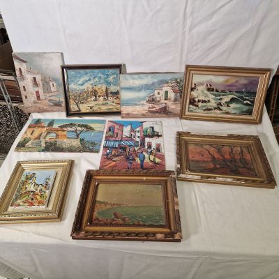 de nombreux tableaux posés sur une table recouverte d'une nappe blanche