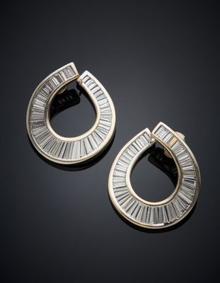une paire de boucles d'oreilles en or et diamants sur une surface noire
