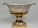 a gold and silver bowl on a stand on a white background