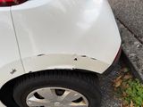 a white car that has been damaged and is parked on the side of the street
