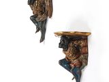 pair of wall sconces in the shape of a man and a woman with a basket on their head