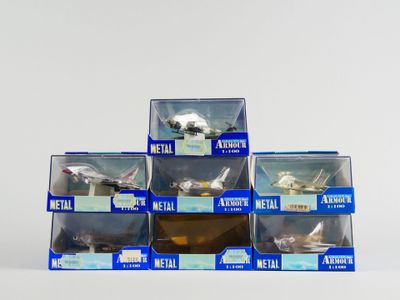 six boîtes de jouets en métal assortis posées sur une surface blanche