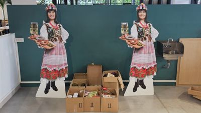 deux figurines en carton représentant une femme tenant une boîte de nourriture