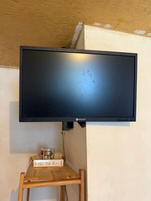 une télévision à écran plat fixée au mur au-dessus d'une petite table