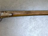 an old wooden rifle laying on top of a metal surface