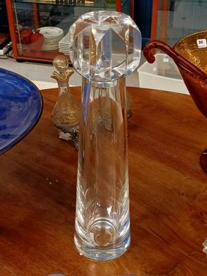 un vase en verre posé sur une table à côté d'un bol bleu