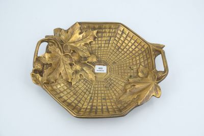 assiette en or décorée de feuilles sur un fond blanc