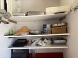 a shelf with pots and pans on it in a kitchen