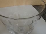 a glass bowl on a counter with a spoon in it