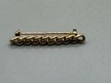 a close up of a gold plated pin with a chain on it