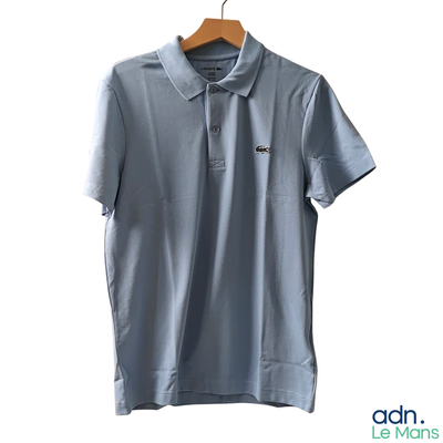 a polo shirt hanging on a hanger on a white wall