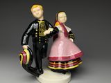 a figurine of a man and a woman holding a suitcase