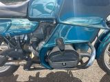 a blue motorcycle that is parked in a parking lot